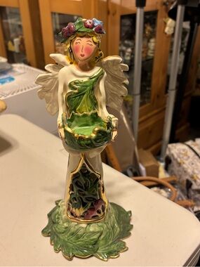 Green Leaf Angel Figurine with Floral Crown. Blue sky. Candle holder